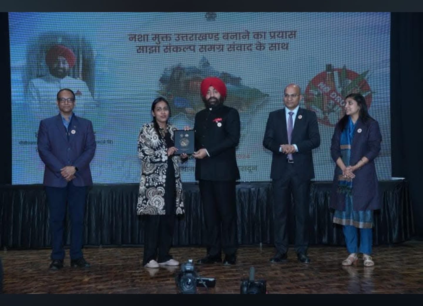 Dr. Nisha Singla receiving a memento from the Governor of Uttarakhand at the Nasha Mukt Uttarakhand event